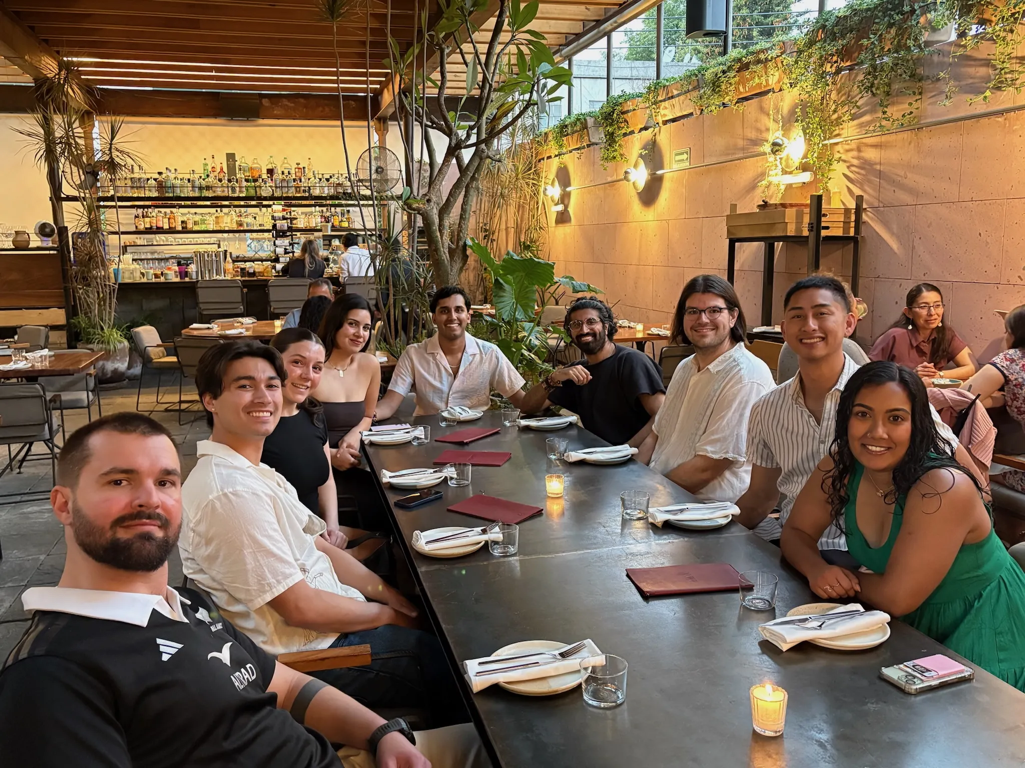 Nine people seated around a dinner table in nice clothes